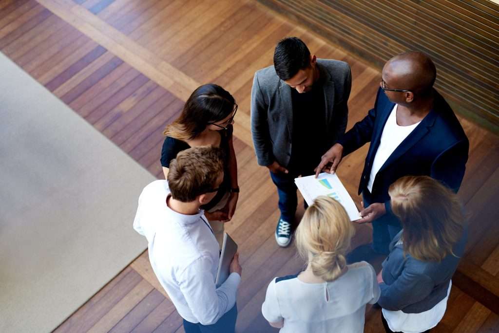 Overhead view of a diverse business team discussing charts in a modern office.